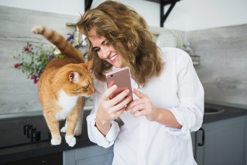 woman showing the phone to her cat